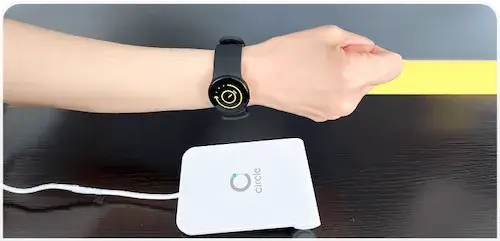 入り口の機械に腕時計式のウェルネスバンドをかざしている画像